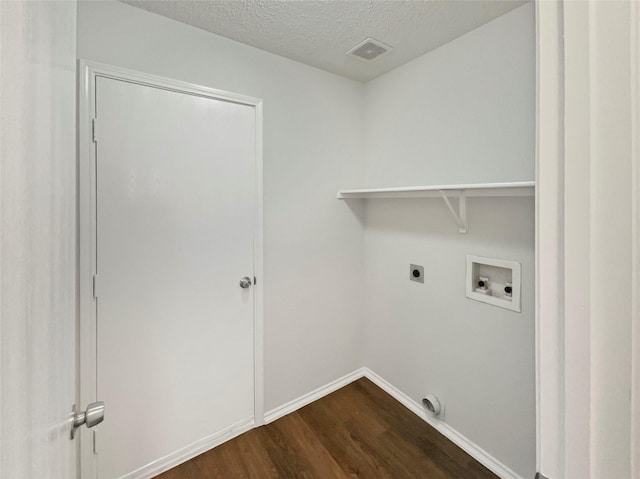 clothes washing area with electric dryer hookup, dark hardwood / wood-style flooring, hookup for a washing machine, and a textured ceiling