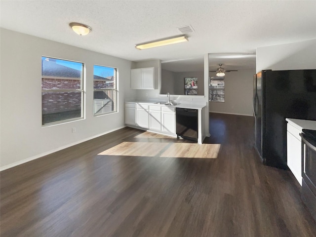 kitchen with white cabinetry, sink, dark wood-type flooring, a textured ceiling, and black appliances