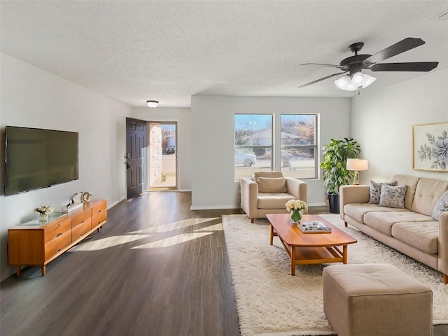 living room featuring ceiling fan, dark hardwood / wood-style floors, and a textured ceiling