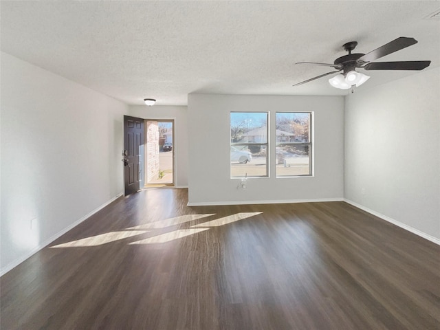 spare room with ceiling fan, dark wood-type flooring, and a textured ceiling