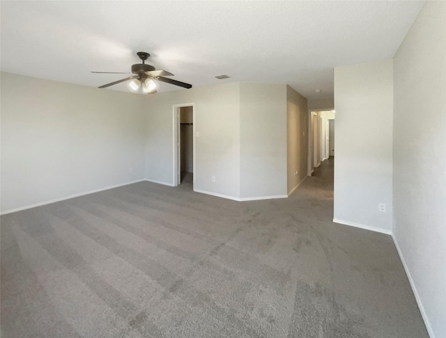 empty room with ceiling fan and dark carpet