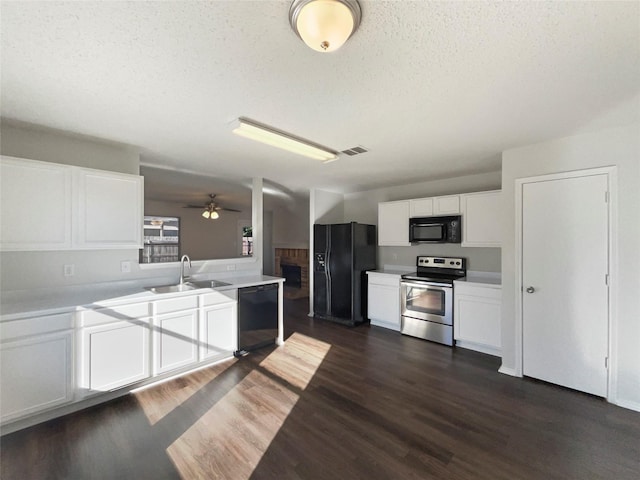 kitchen featuring ceiling fan, sink, dark hardwood / wood-style floors, white cabinets, and black appliances