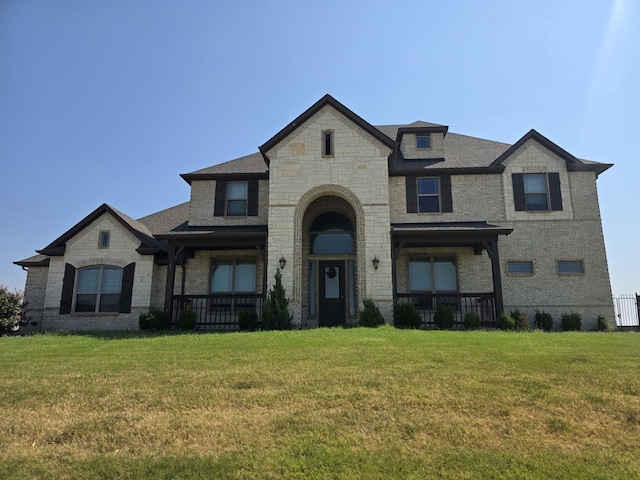 french country inspired facade featuring a front lawn