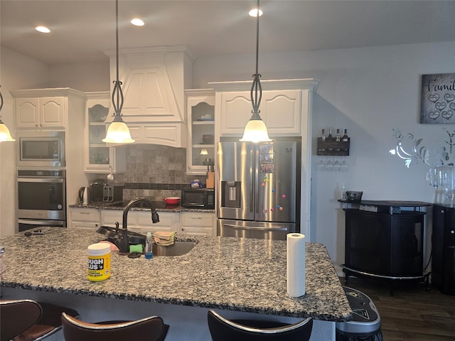 kitchen featuring white cabinets, appliances with stainless steel finishes, hanging light fixtures, and sink