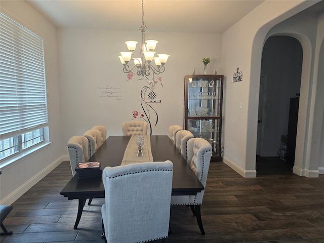 dining room with dark hardwood / wood-style flooring and a chandelier