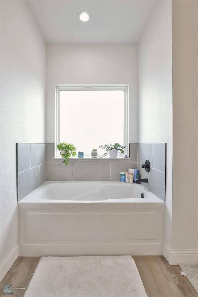 bathroom with a bathing tub and wood-type flooring