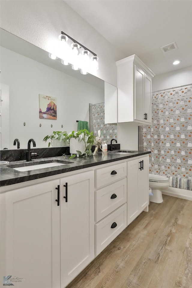 bathroom featuring vanity, decorative backsplash, toilet, walk in shower, and wood-type flooring