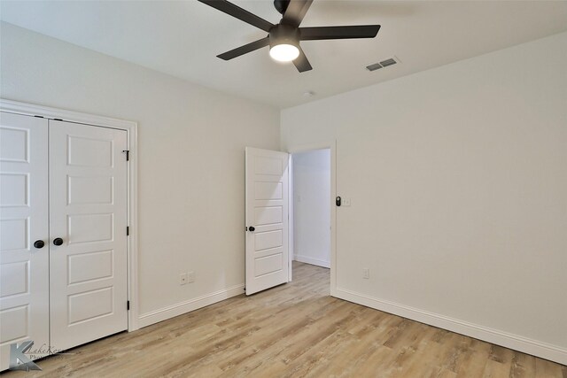 unfurnished bedroom with light wood-type flooring, a closet, and ceiling fan