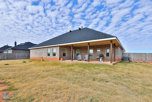 back of house featuring a lawn, a patio area, and central AC