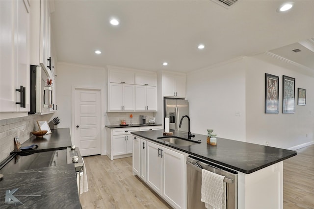 kitchen featuring a center island with sink, white cabinetry, sink, and appliances with stainless steel finishes