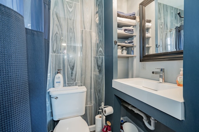 bathroom with toilet, sink, and walk in shower