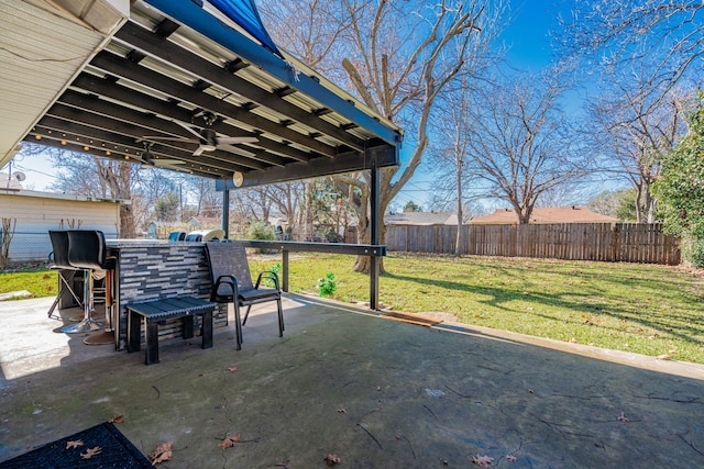 view of patio with ceiling fan and a bar