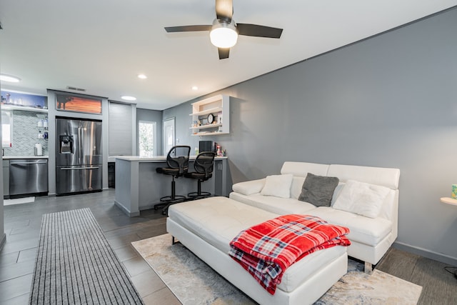 bedroom with ceiling fan and stainless steel fridge with ice dispenser