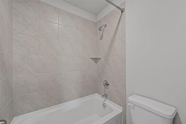 bathroom with tiled shower / bath combo and toilet