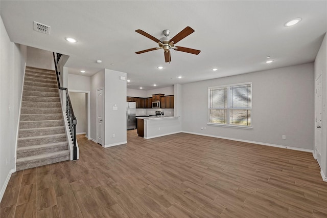 unfurnished living room featuring hardwood / wood-style floors and ceiling fan