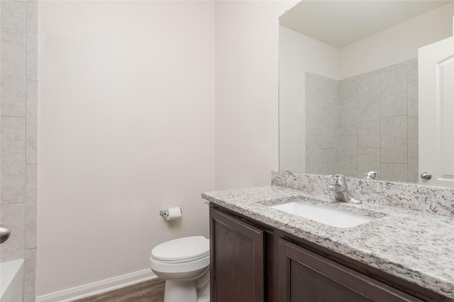 bathroom featuring toilet, wood-type flooring, and vanity