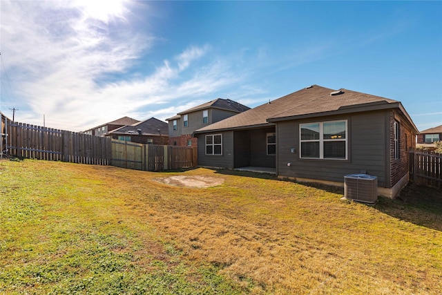 back of house featuring a lawn and central AC