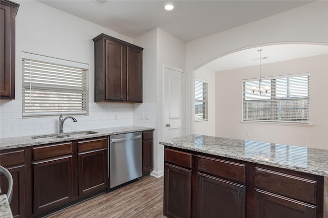 kitchen featuring dishwasher, a chandelier, light hardwood / wood-style floors, backsplash, and sink