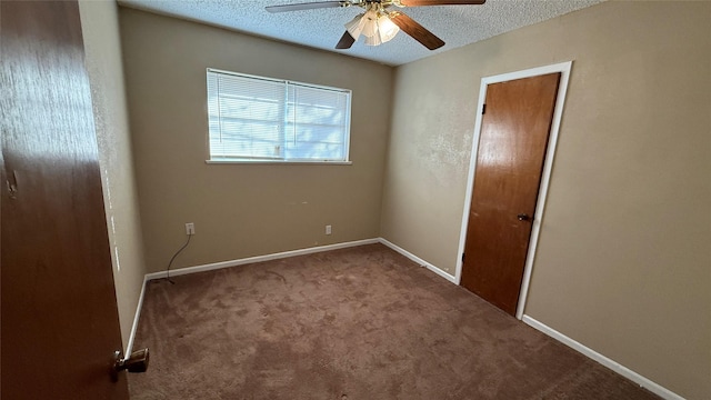 empty room featuring ceiling fan, carpet, and a textured ceiling