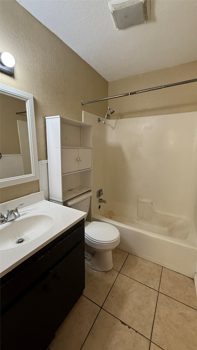 full bathroom with vanity,  shower combination, toilet, tile patterned floors, and a textured ceiling