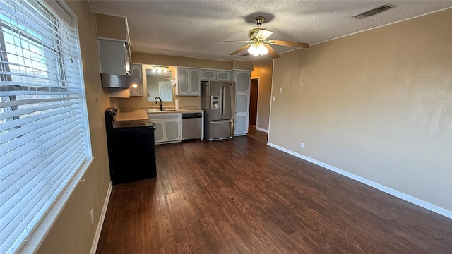 kitchen with stainless steel appliances, sink, a textured ceiling, and dark hardwood / wood-style floors