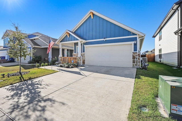 view of front of home with a front yard, a garage, and covered porch