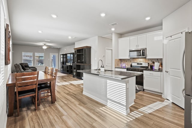 kitchen with sink, white cabinetry, a kitchen island with sink, and appliances with stainless steel finishes