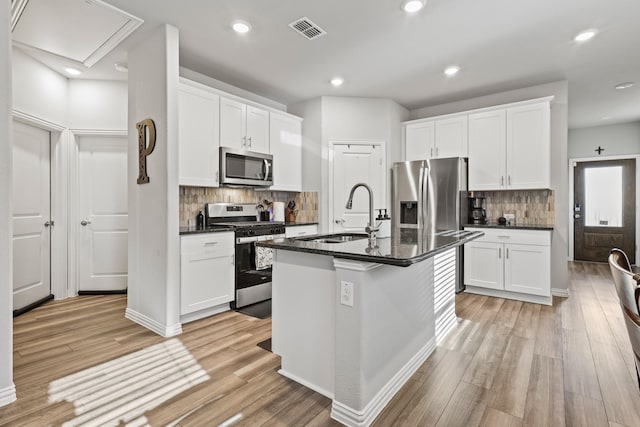 kitchen featuring a center island with sink, white cabinets, and appliances with stainless steel finishes