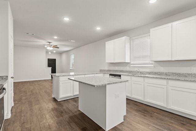 kitchen with white cabinetry, a center island, ceiling fan, and kitchen peninsula