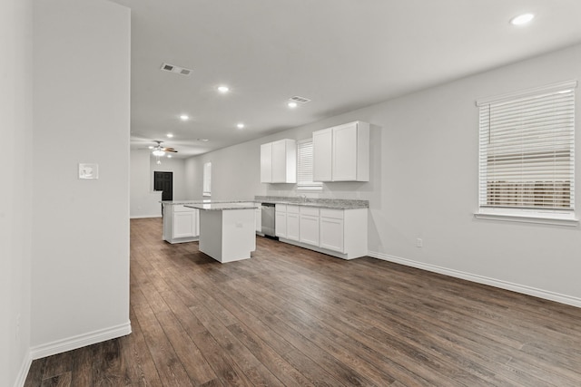 kitchen with stainless steel dishwasher, dark hardwood / wood-style floors, a center island, and white cabinets