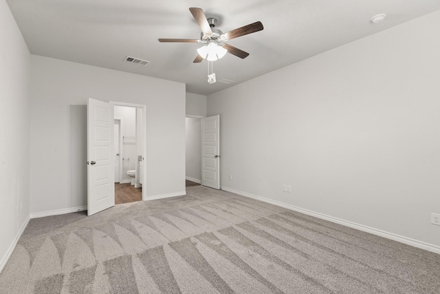 unfurnished bedroom featuring light carpet, connected bathroom, and ceiling fan