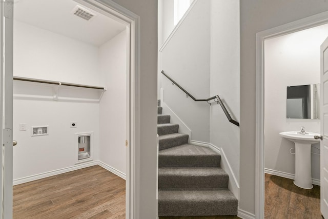 stairway featuring sink and hardwood / wood-style floors