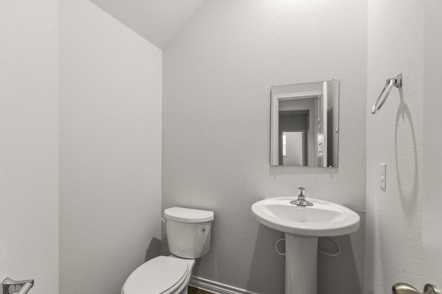 bathroom with lofted ceiling and toilet