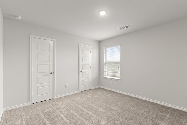 unfurnished room featuring light colored carpet