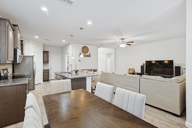 dining area with sink, ceiling fan, and light hardwood / wood-style flooring