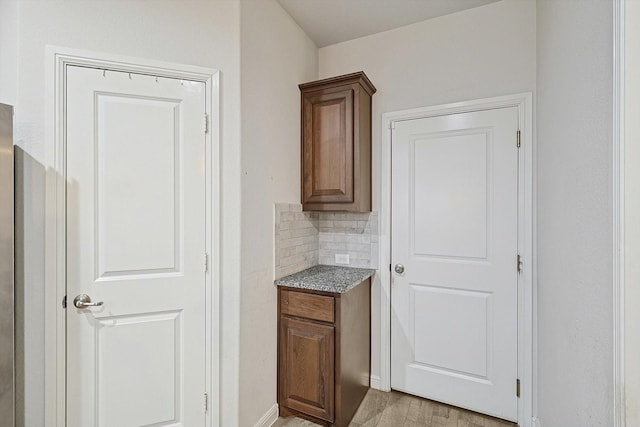 bar with backsplash and light wood-type flooring