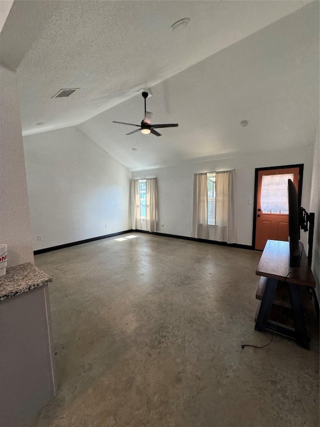 unfurnished living room featuring concrete flooring, a textured ceiling, vaulted ceiling, and ceiling fan