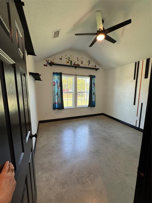 spare room featuring a textured ceiling, ceiling fan, and lofted ceiling