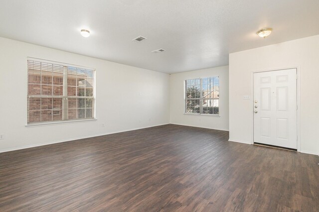 hallway with a textured ceiling and dark hardwood / wood-style floors