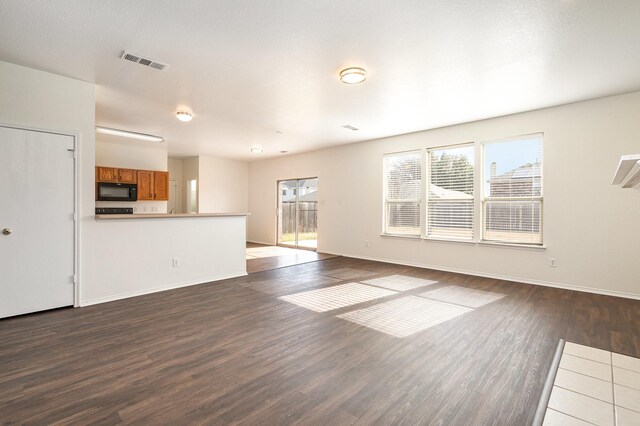 unfurnished living room with a textured ceiling and dark hardwood / wood-style floors