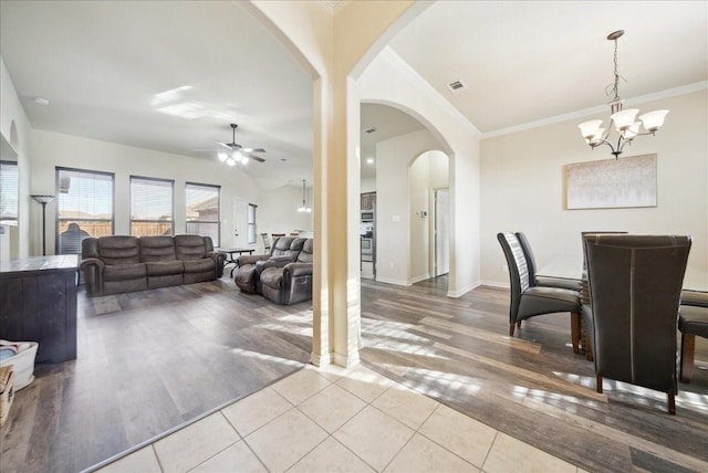 tiled dining area featuring ceiling fan with notable chandelier and ornamental molding