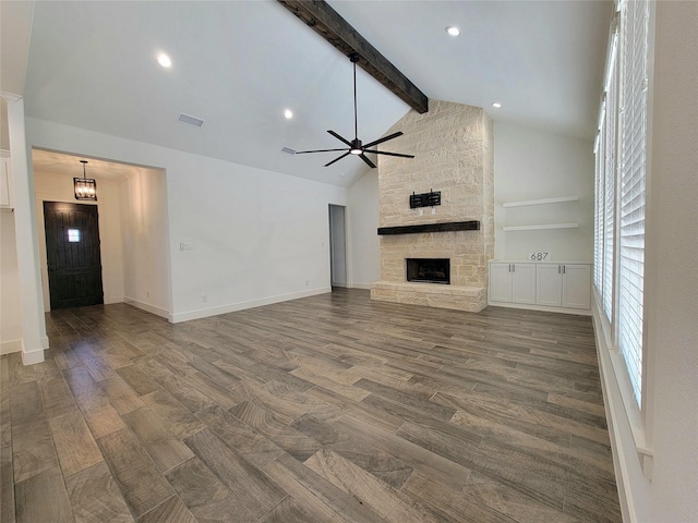 unfurnished living room with ceiling fan, beam ceiling, a fireplace, and high vaulted ceiling