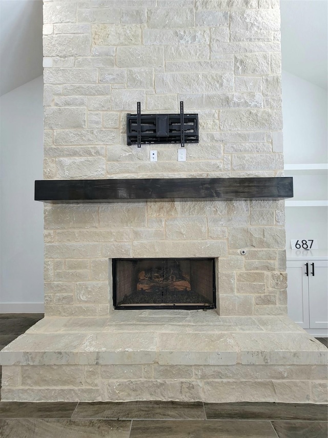 interior details featuring hardwood / wood-style flooring and a stone fireplace