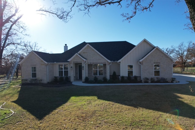 view of front of home featuring a chimney, board and batten siding, and a front yard