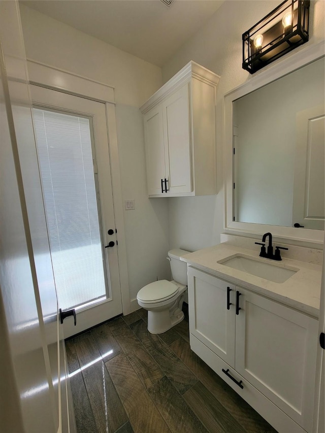 bathroom featuring vanity, hardwood / wood-style flooring, and toilet