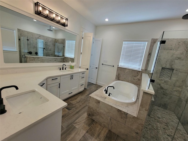 bathroom with hardwood / wood-style floors, vanity, separate shower and tub, and a wealth of natural light