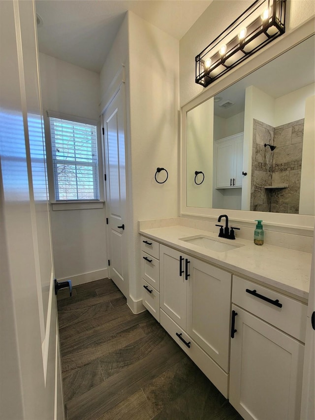 bathroom with a shower, vanity, and hardwood / wood-style flooring