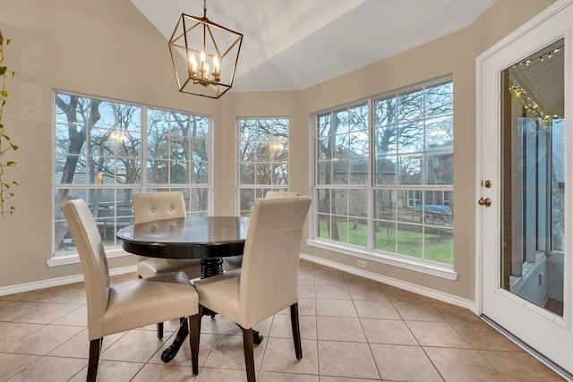 tiled dining room featuring lofted ceiling and a chandelier