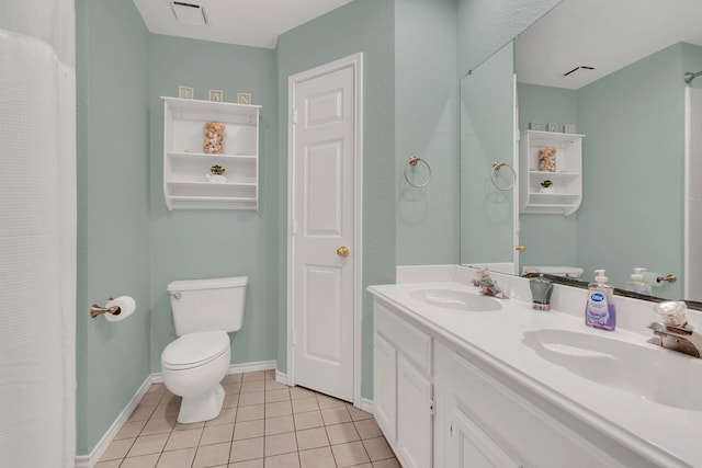 bathroom with toilet, vanity, and tile patterned floors