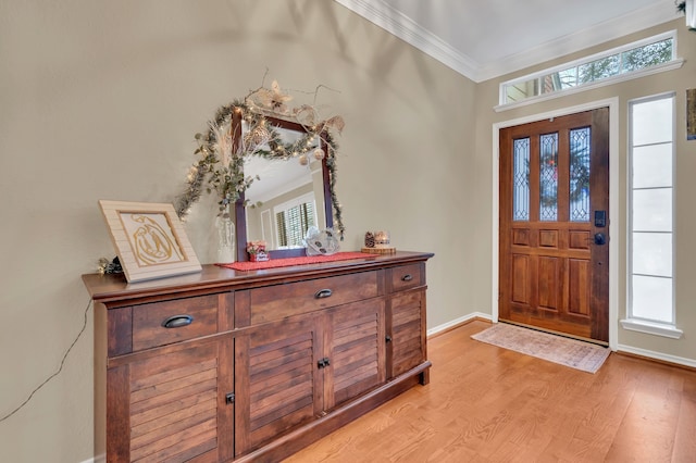 foyer with crown molding and light hardwood / wood-style flooring